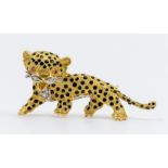 A Cartier style ruby and diamond set gold metal brooch in the form of a leopard, ruby set eyes,