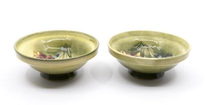 A pair of Moorcroft 'Spring Flower' small footed bowls designed by Walter Moorcroft on light green