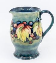 A leaf and berry Moorcroft glazed jug, signed, approx. 15cm high. Condition: good