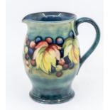 A leaf and berry Moorcroft glazed jug, signed, approx. 15cm high. Condition: good