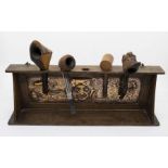 Arts & Crafts pipe rack with embossed copper panel depicting smoking man plus four pipes. Length