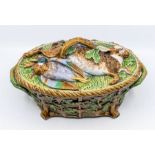 A 19th Century majolica Game Pie Dish, the cover modelled as rabbit and duck resting on leaves,