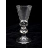 A very rare Georgian heavy baluster wine glass with drop knop, circa 1725, thistle bowl with an