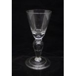 A Georgian baluster wine glass, circa 1725, round funnel bowl with an air tear in the base, an