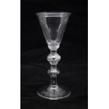 A Georgian light baluster wine glass, circa 1740, conical bowl set on an annulated collar, above