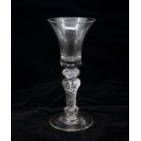 A Georgian rare form early composite stem wine glass, circa 1740, bell bowl above a triple annulated