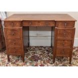 An oak kneehole desk circa 1930, of nine fitted drawers, on short tapered legs, 109cm wide