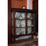 A mahogany bow fronted display cabinet in Georgian style circa 1920,  on dwarf cabriole legs with