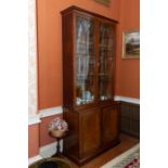 A mahogany bookcase cabinet, 19th century, with upper narrow astragal glazed doors, reeded