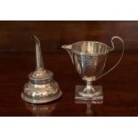 A George III silver Cream Jug engraved with pendant husk swags and oval vacant cartouches, on