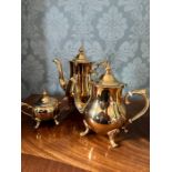 A set of gold plated tea pot, coffee pot and sugar bowl, with bone inlaid handles, in unused