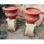 A pair of Victorian style partly fluted cast iron garden vases with mask handles (incomplete) on