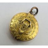 A Victorian circular buckle locket or loupe pendant in yellow metal, featuring ornate engraving