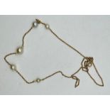 A pearl and yellow metal Edwardian station necklace, featuring five graduated pearls on a chain