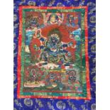 A late 20th century Thangka of six armed Mahakala, gouache on cotton, within silk border, 74cm x