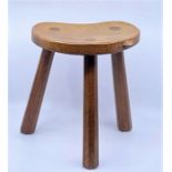 A Robert "Mouseman" Thompson oak three legged stool, the dished kidney shaped seat with carved mouse