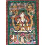A late 20th century Sino-Tibetan Thangka  of a Buddhist deity, gouache on cotton, within silk