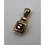 An 18ct yellow gold square cut garnet pendant. Gross weight approximately 1.3 grams. (1)