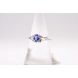 A sapphire and diamond dress ring, featuring a pale blue sapphire and four melee diamonds. Size N.