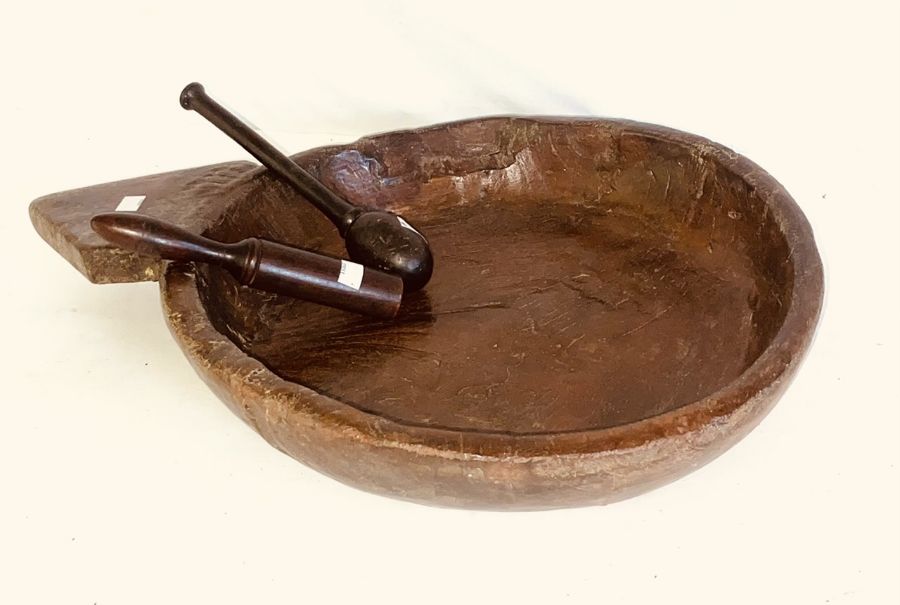 An 18th century elm treen dairy bowl; a later fruitwood masher; another mahogany similar (3)