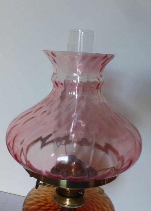 A tall Victorian oil lamp. Brass based with Cranberry and Amber glass. sat on a black glass - Image 2 of 4