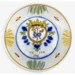 A French faience plate decorated with crown and flowers, 23cm diameter