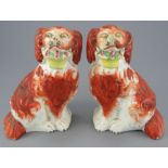 A pair of mid-nineteenth century Staffordshire seated dogs with baskets c. 1840-60. Each is well-