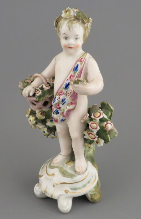 A late eighteenth century porcelain Derby cherub with applied floral decoration and hand-painting,