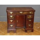 A 19th century mahogany kneehole desk, the rectangular top over an arrangement of seven drawers with