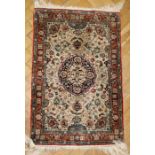 A small 20th century Kashmiri silk mat, woven with central disc medallion on a busy foliate field,