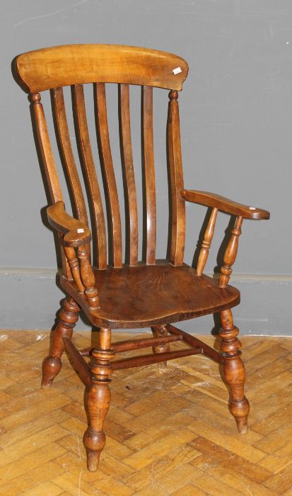 A 19th century beech and elm lathe back armchair, with broad rail, outswept arms, saddle seat, on