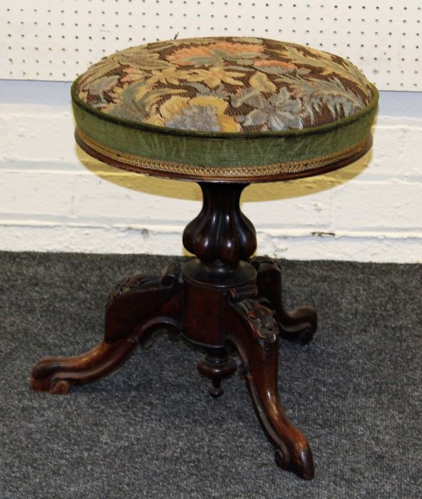 A Victorian rosewood piano stool, floral and green plush upholstered circular adjustable seat, on