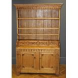 A late 19th/ early 20th century Continental pine tall dresser, the moulded and fret carved cornice