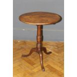 A George III provincial oak occasional table, the circular plank top raised on tripod supports,