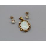 An Australian opal pendant and earring set featuring a 17mm and 13mm opal cabochon in a yellow metal