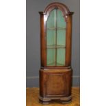 A reproduction Queen Anne style walnut floorstanding corner cupboard, the dome top over glazed