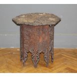 An early 20th century Colonial carved hardwood low table, the octagonal top richly decorated with