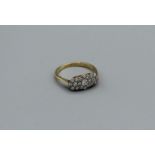 An East to West diamond cluster ring set in yellow metal, stamped 18ct, size L1/2, gross weight