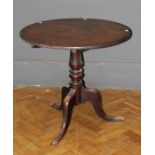 A George III oak tripod table, the circular snap top on a baluster turned column, downswept legs and