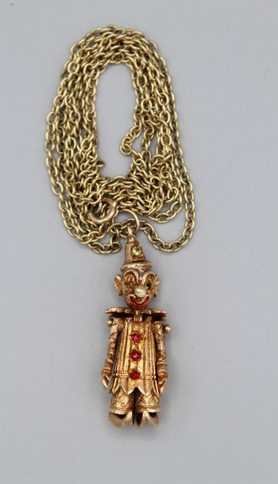 A rose - yellow metal paste and enamel set articulated clown pendant along with a 23 inch trace