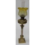 An Edwardian paraffin lamp with frilled lemon tinted etched glass shade, brass reservoir on