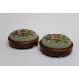 A pair of Victorian walnut bun form footstools, each with gros point floral tapestry pad, on ceramic