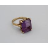 A step cut Amethyst cocktail ring in yellow metal setting stamped 18ct, size O, gross weight