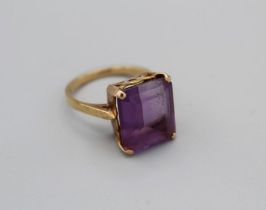A step cut Amethyst cocktail ring in yellow metal setting stamped 18ct, size O, gross weight