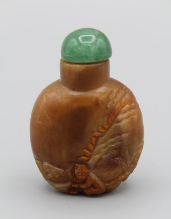 Chinese snuff bottle. Quartzite of flattened rounded form, carved in relief using reddish layer in