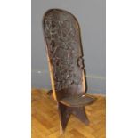 A 20th century African carved coromandal touristware chair. The sloping back decorated with