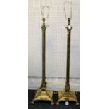 A pair of Edwardian brass standard lamps, each of Corinthian column form, on stepped loaded square