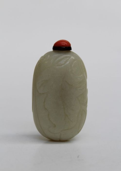 A 19th Chinese leaf carved jade snuff bottle with coral bead stopper, 7cm