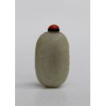 A 19th Chinese leaf carved jade snuff bottle with coral bead stopper, 7cm