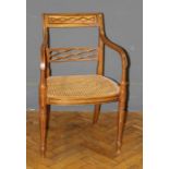 An Edwardian satinwood, parquetry inlaid open armchair, with cane upholstered seat, on simulated